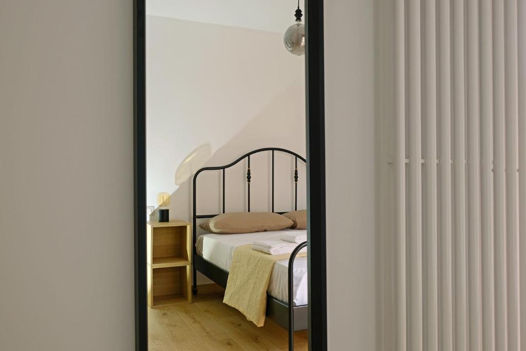 1 dormitorio con cama y espejo en Appartamenti Alle 5 Torri, en Mezzolombardo