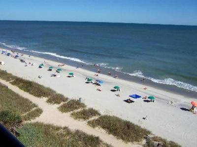 Ein Strand mit vielen Leuten und Sonnenschirmen in der Unterkunft Club Regency at Regency Towers in Myrtle Beach