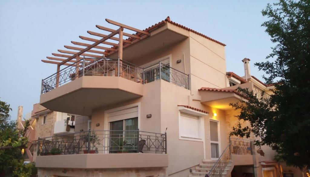 a large white house with a balcony at Villa Tsios in Artemida