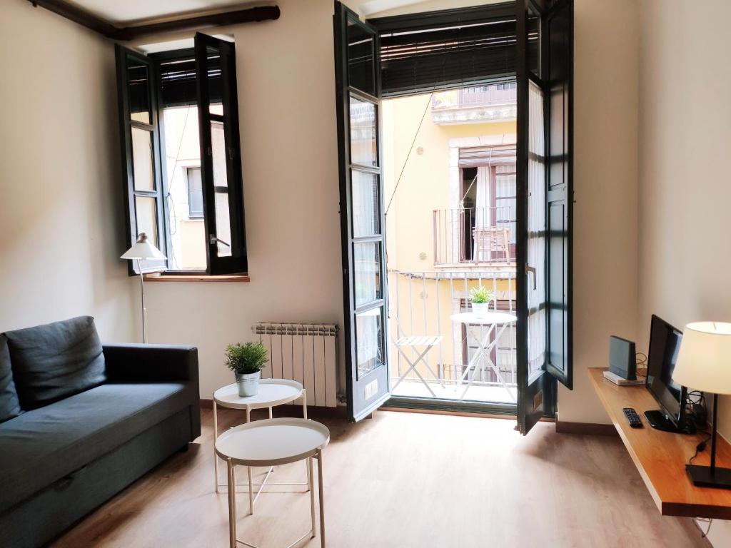 uma sala de estar com um sofá e uma grande janela em Apartment Histórico em Girona