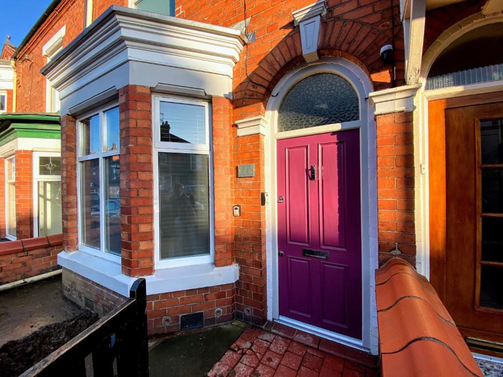 a purple door on the side of a brick building at 77 Underwood Lane in Crewe