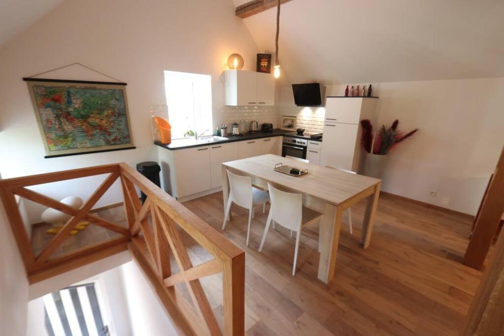 uma cozinha com mesa e cadeiras num quarto em Loft à la campagne/ 1ère occupation em Visé