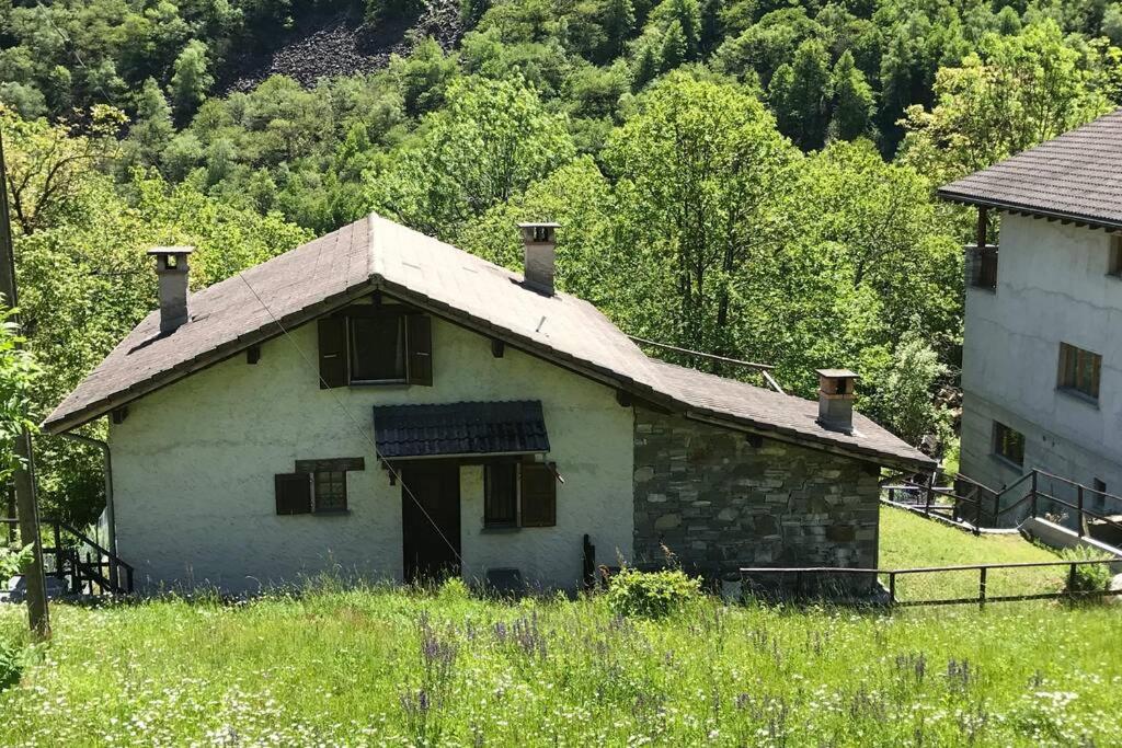 stary kamienny dom pośrodku pola w obiekcie Casa Cantoni w mieście Menzonio