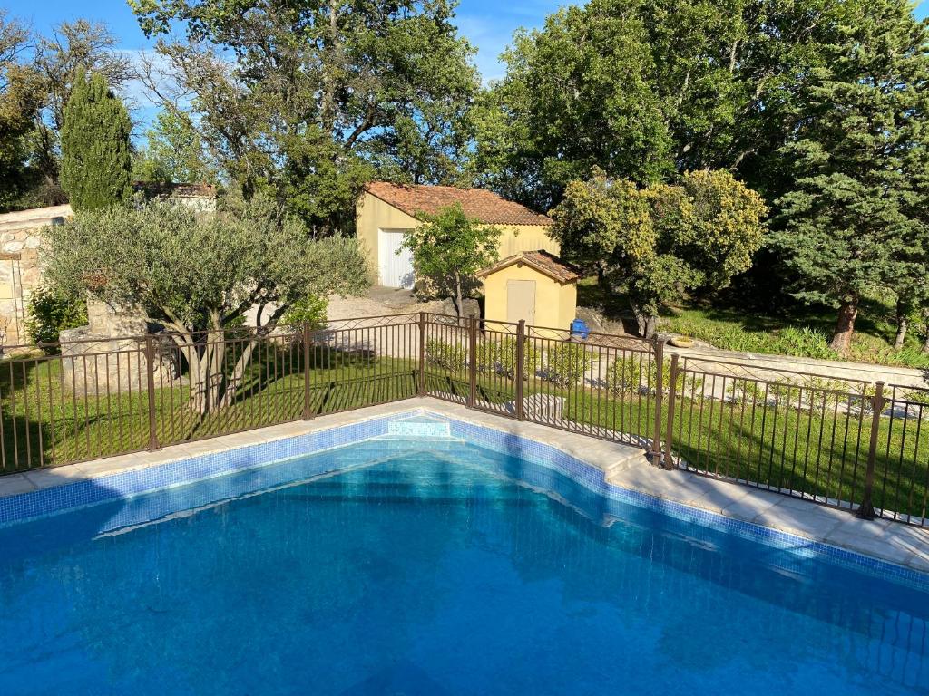 une grande piscine bleue en face d'une clôture dans l'établissement Studio au Pied de la ste Victoire, à Puyloubier