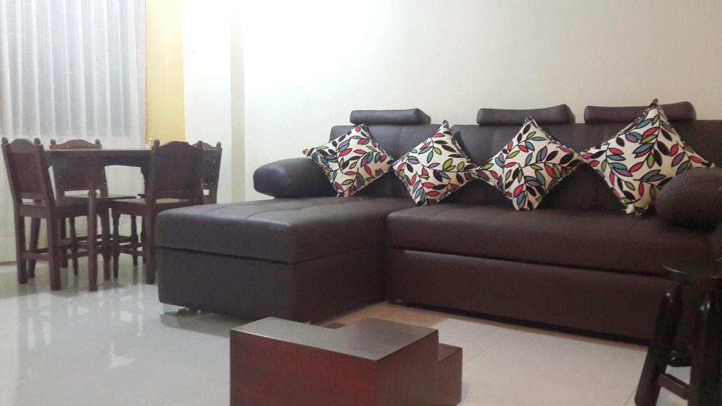 een woonkamer met een bruine bank met kussens bij Apartamentos Edificio Diamante in Paipa