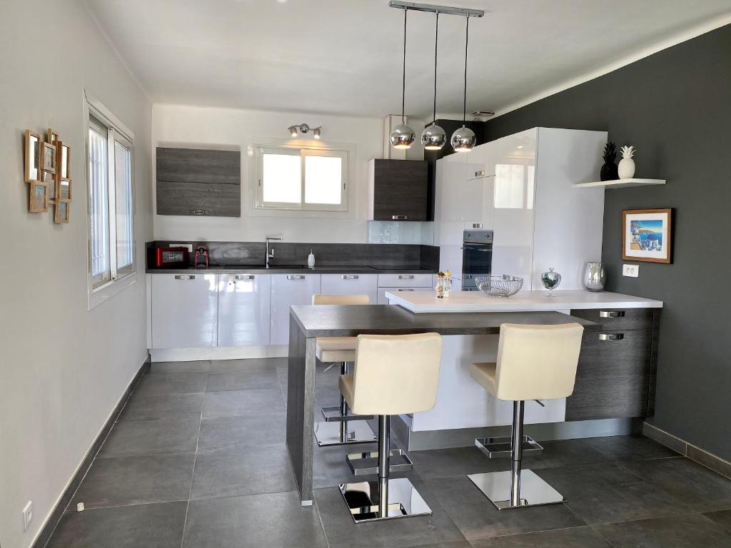 a kitchen with white cabinets and a table and chairs at Le Bellevue in Saint-Paul-de-Vence