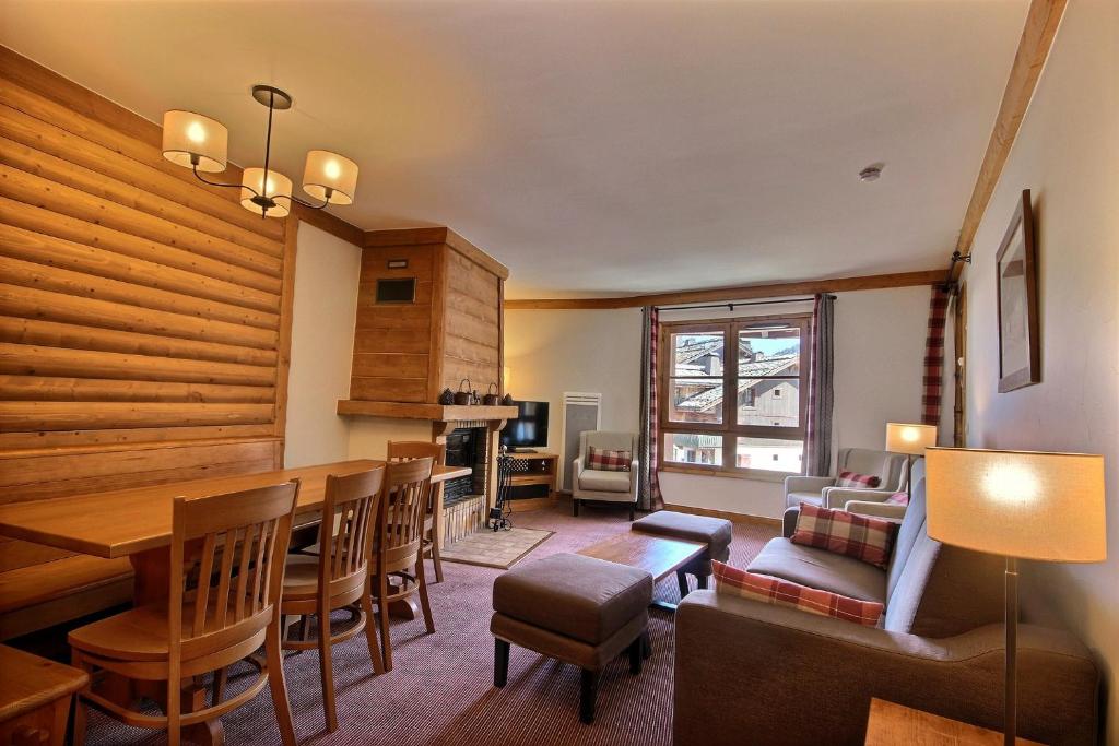 a living room with a table and chairs and a fireplace at Auberge jérôme 614 - Arc 1950 - Duplex prestige 4 rooms 3 bedrooms for 6-8 people 5-star residence Auberge Jérôme - village heart in Arc 1950