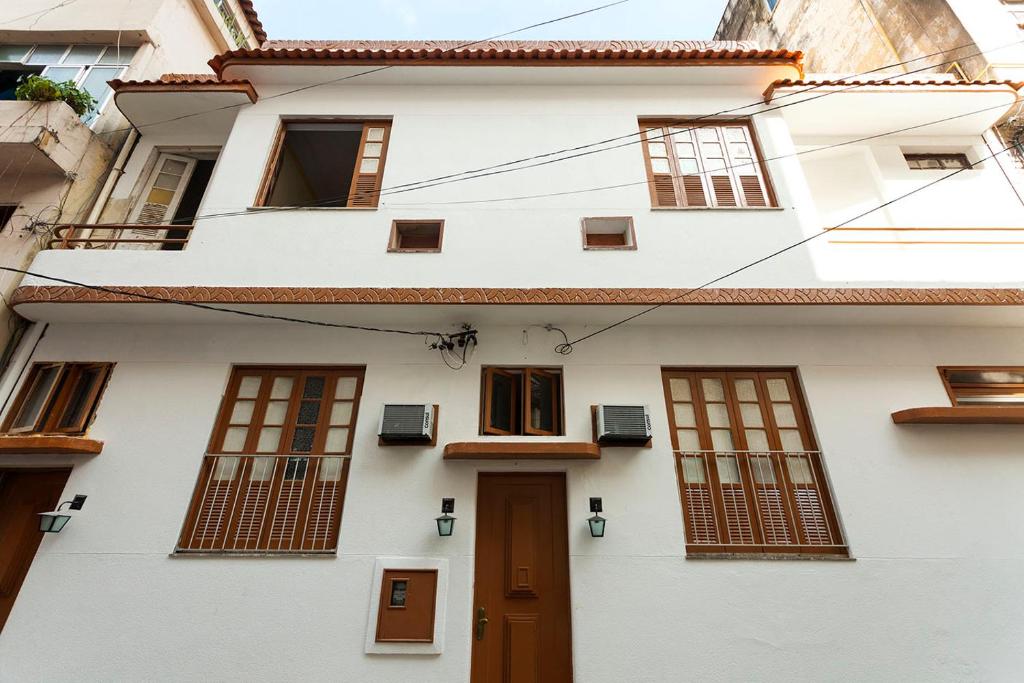 Casa blanca con ventanas y puerta en Casa Saga - All Suites, en Río de Janeiro