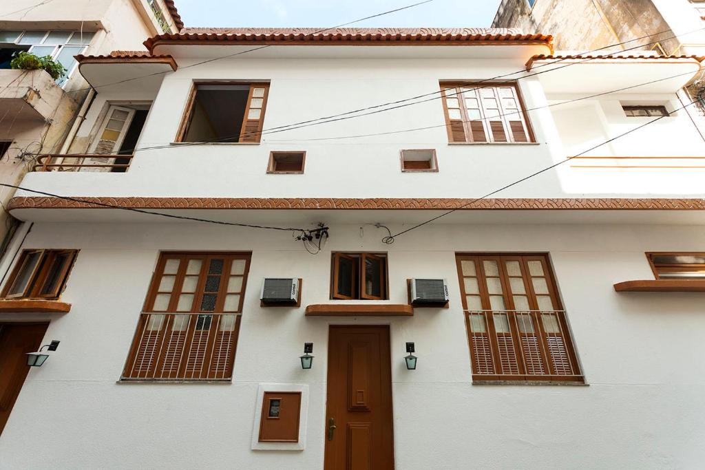 uma casa branca com janelas e uma porta em Casa Saga - All Suites no Rio de Janeiro