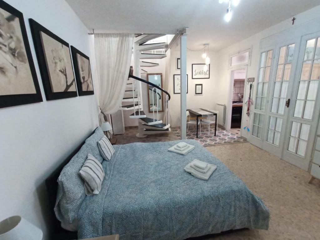 a bedroom with a blue bed and a staircase at Alloggio Turistico nel Borgo Antico di Gaeta in Gaeta