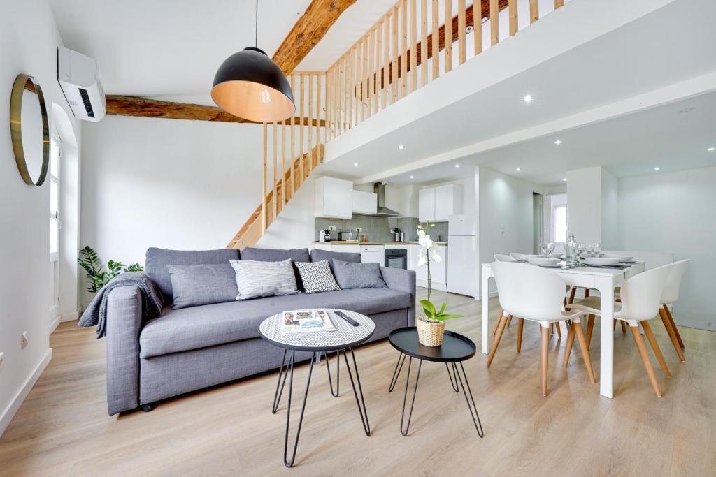 a living room with a couch and a table at Confortable Rooftop view Appart Hôtel Avignon in Avignon