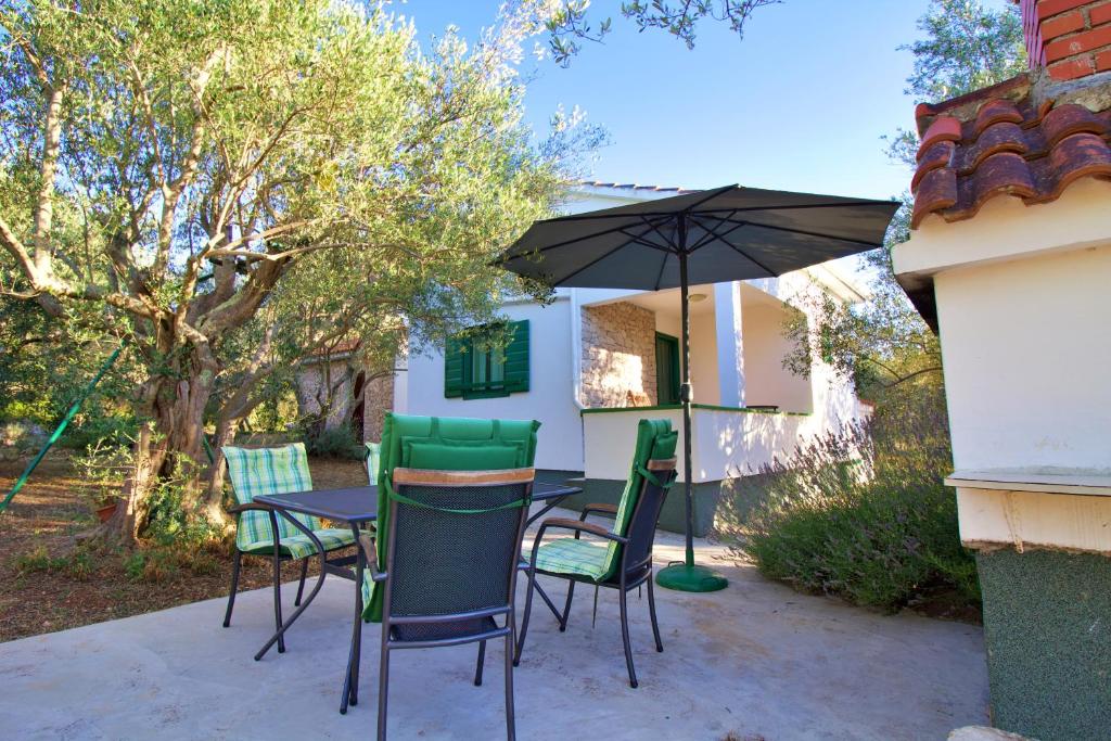a table and chairs with an umbrella on a patio at Holiday house Silvana in Ždrelac