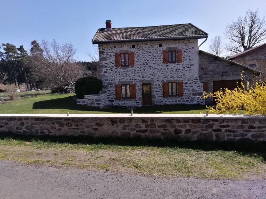 une ancienne maison en pierre sur le côté d'une route dans l'établissement Maison de campagne, à La Chapelle-Geneste