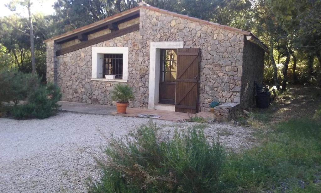a small stone house with a door and a window at LES PAPILLONS in Flassans-sur-Issole