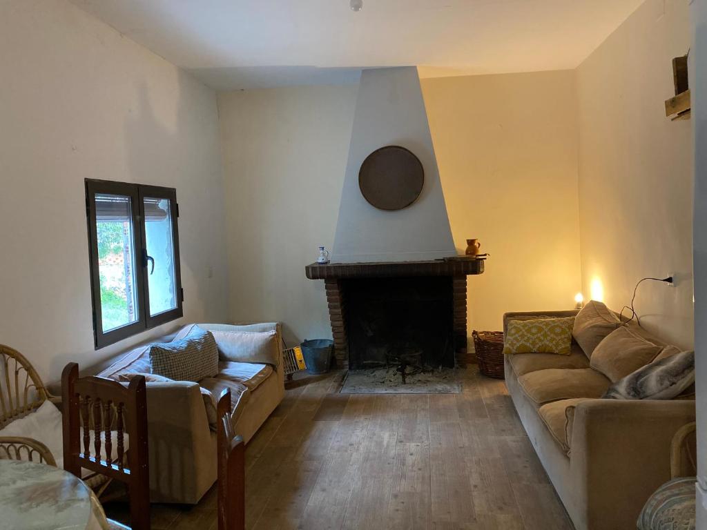 sala de estar con sofá y chimenea en Casa Pueblo, en Navas de Estena