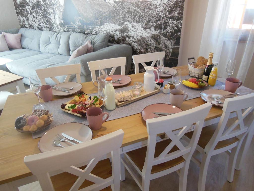 a dining room table with plates and food on it at Landhaus Huchatz in Burg