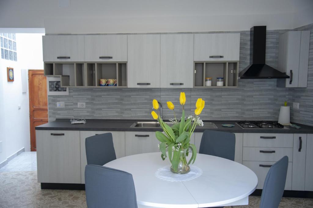 a kitchen with a vase with yellow flowers on a table at Cetara Sunny House in Cetara