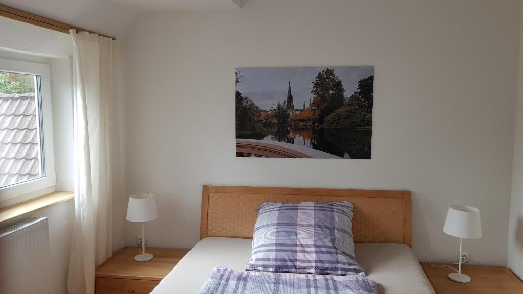 - une chambre dotée d'un lit avec une photo sur le mur dans l'établissement Zentrumnahe, moderne Wohnung mit Terrasse, à Oldenbourg