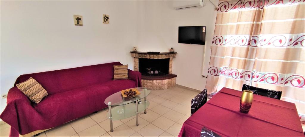 - un salon avec un canapé rouge et une cheminée dans l'établissement Fani's apartments 3, à Ancient Epidavros