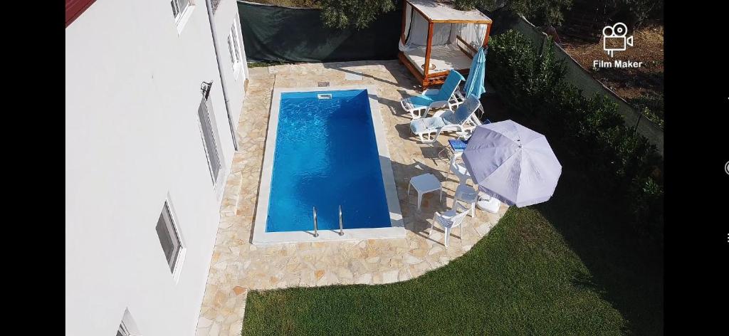 uma vista superior de uma piscina com um guarda-sol em Zelena Maslina em Bar