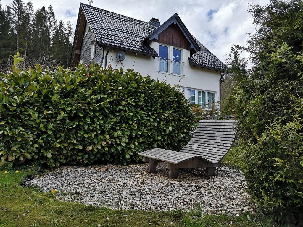 un banc en bois assis devant une maison dans l'établissement Apartment Sommer, à Winterberg