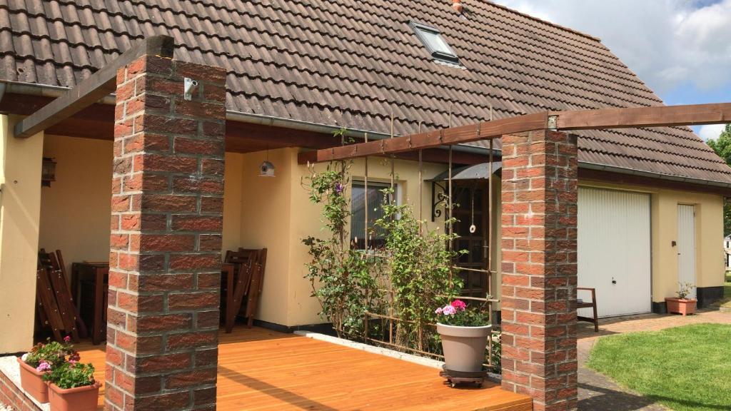 a house with a brick pillar and a wooden deck at Ferienhaus Fienstorf in Steinfeld