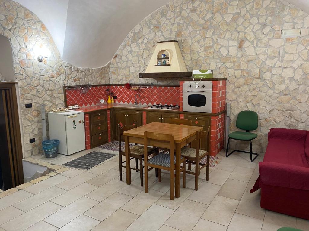uma cozinha com uma mesa e um fogão forno superior em Casasofé em Vico del Gargano