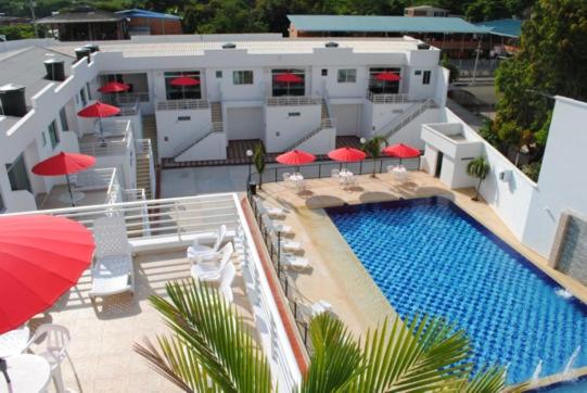 a building with a swimming pool and red umbrellas at Apartamento Quinta Avenida in Melgar