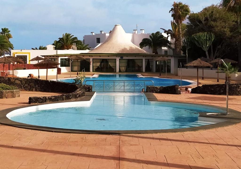 a large swimming pool in front of a building at Villa Sun and sea 1 front de mer Playa Rocca Costa Teguise in Costa Teguise