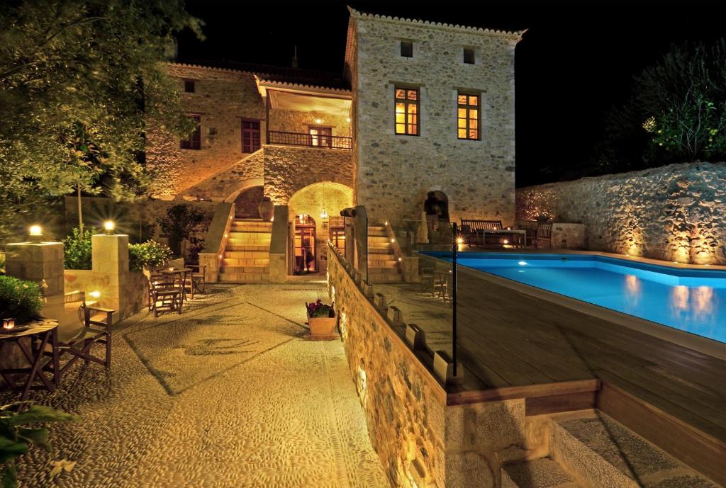 eine Villa mit einem Pool in der Nacht in der Unterkunft Archontiko Chioti in Leonidi