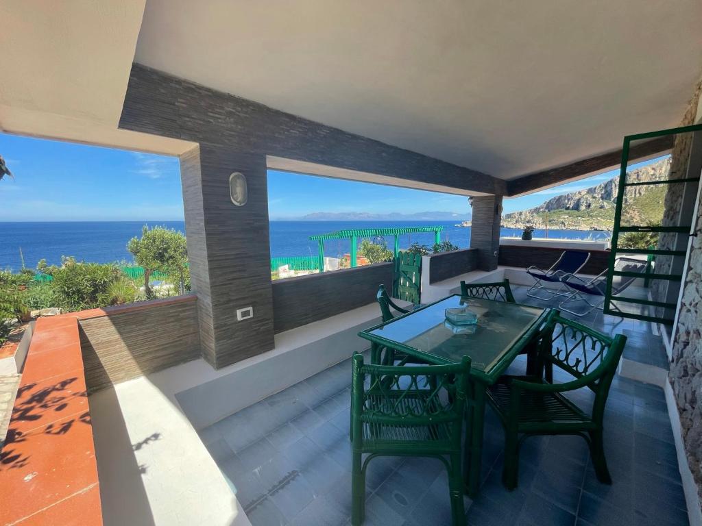 a balcony with a table and chairs and the ocean at Villa Venere al Sauce - esclusiva villa sul mare in San Vito lo Capo