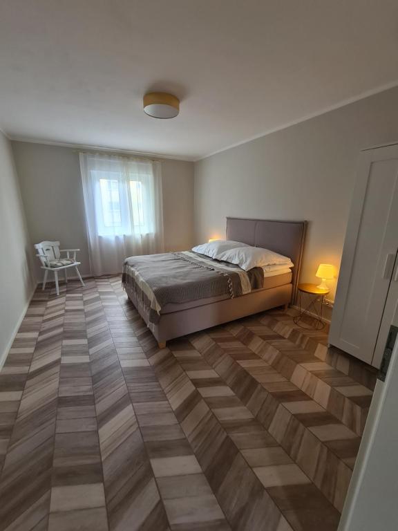 a bedroom with a bed and a wooden floor at Highfield 2 rooms Apartment in Augsburg