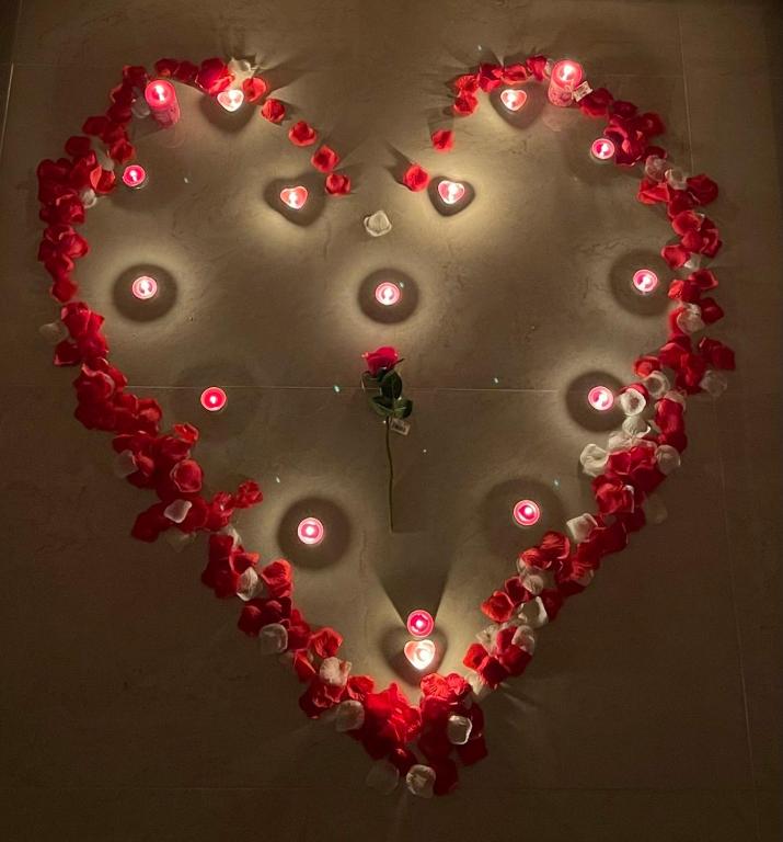 a heart shaped mirror with lights on a wall at Apartments Gusar in Ulcinj