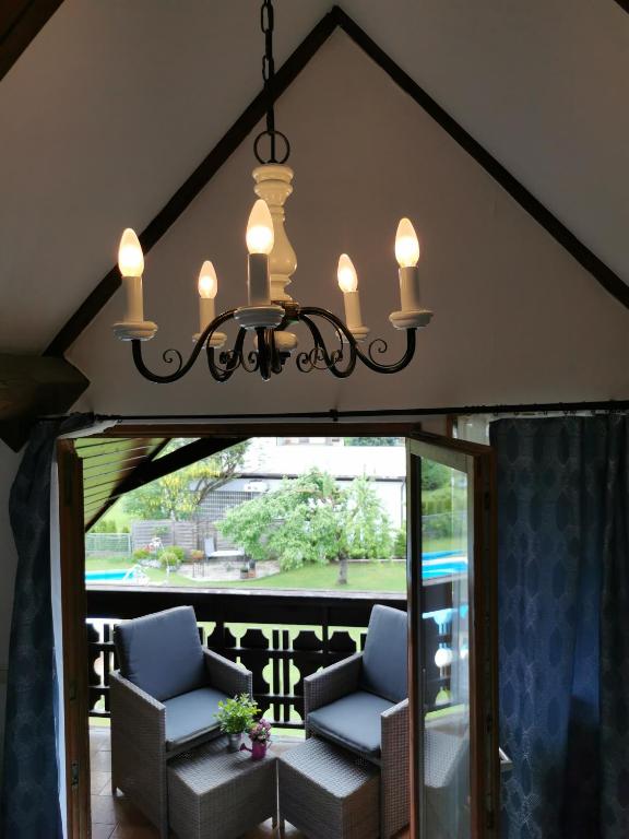 a chandelier hanging over a porch with two chairs at Stadl Suite in Sankt Margarethen im Lavanttal