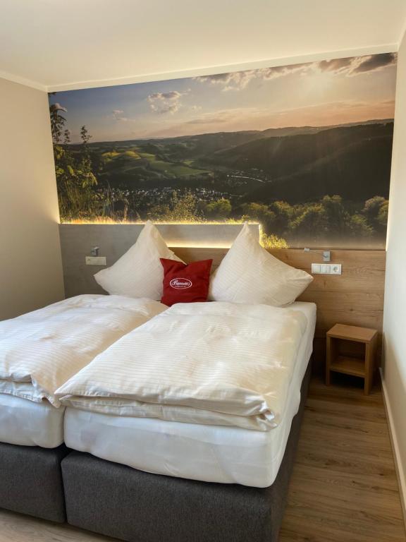 a bedroom with two beds with a painting on the wall at Paganetti´s Chalet in Breitscheid