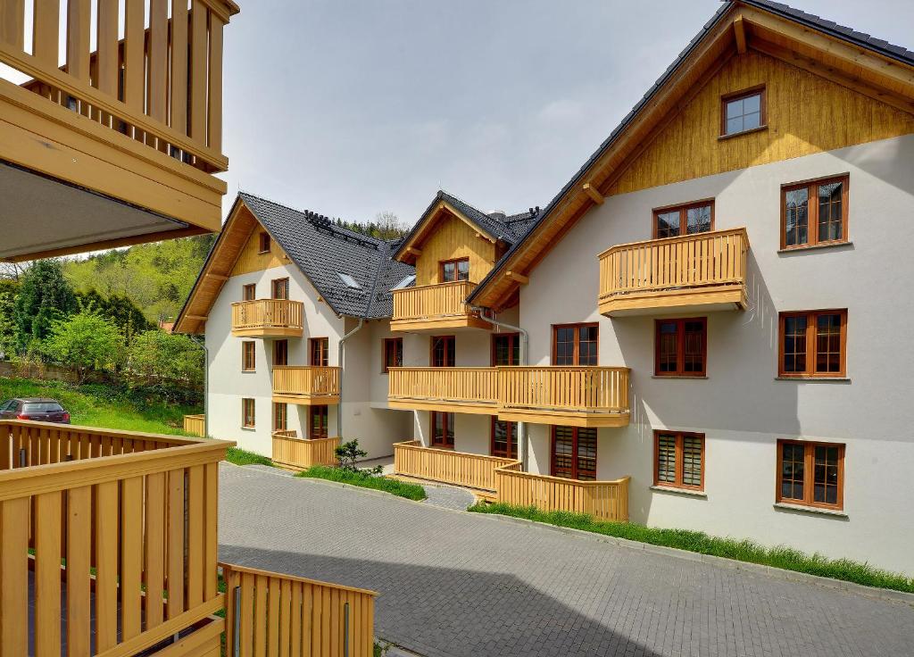 an apartment building with wooden balconies and a driveway at Karpacz4you -"PRZY DEPTAKU" Apartament z Garażem - Wakacje 2024 in Karpacz