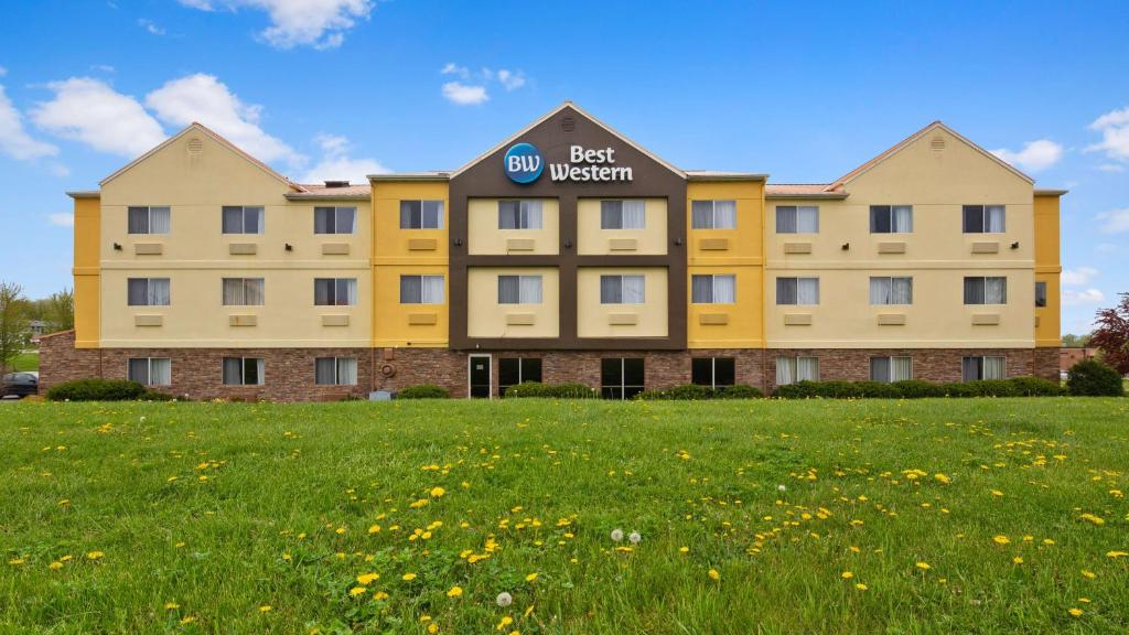 a yellow best western hotel with a field of flowers at Best Western Muscatine - Pearl City Hotel in Muscatine