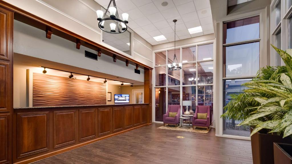 a lobby with wood paneling and purple chairs at Best Western Plaza Inn in Pigeon Forge