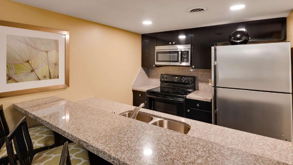 a kitchen with a stainless steel refrigerator and appliances at Best Western Plaza Inn in Pigeon Forge