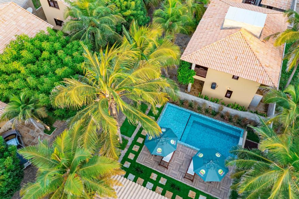 uma vista aérea de um resort com uma piscina e palmeiras em Sombra do Coqueiro Villas - 150m da Praia em Luís Correia