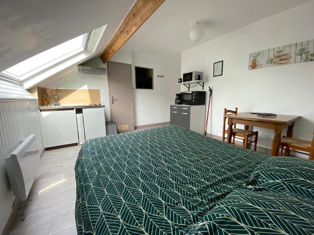 um quarto com uma cama com um edredão verde em Une escapade tranquille, proche de la plage ! em Dunkerque