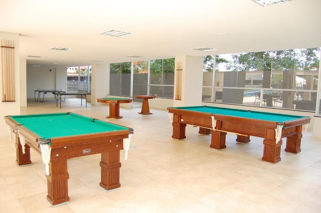 2 mesas de billar en una habitación grande con ventanas en Park Veredas Flat Service 1 Quarto, en Rio Quente