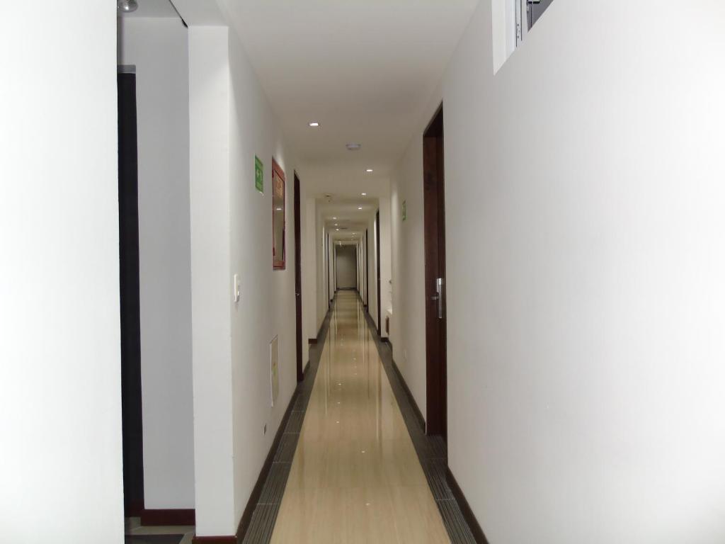 a hallway with white walls and a long hallway at Hotel Paradise del Cafe in Pereira