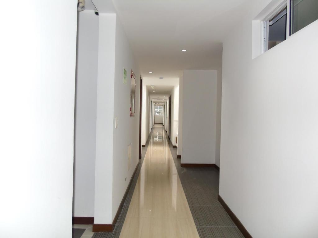 a hallway with white walls and a long hallway at Hotel Paradise del Cafe in Pereira
