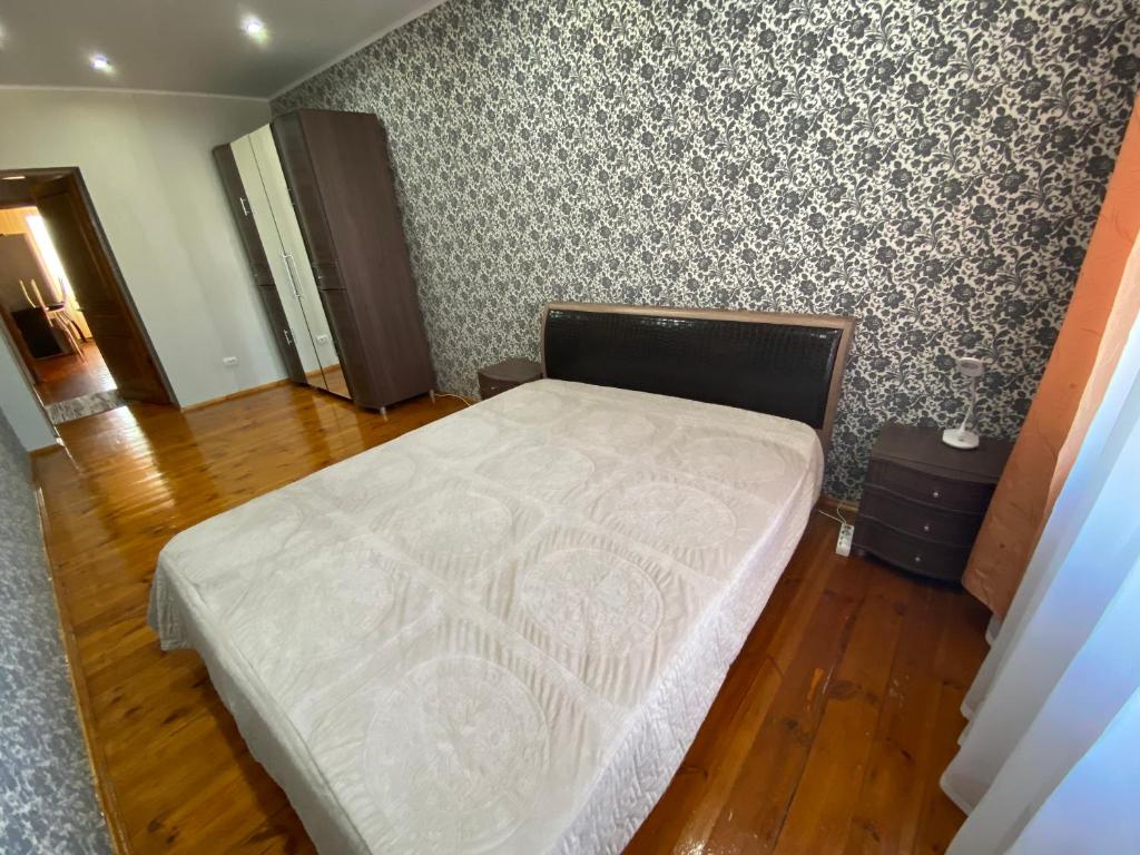 サレハルドにあるApartaments on Zoi Kosmodemiyanskoy 39 street - апартаменты на улице Зои Космодемьянской дом 39の壁のある部屋のベッド1台が備わるベッドルーム1室を利用します。