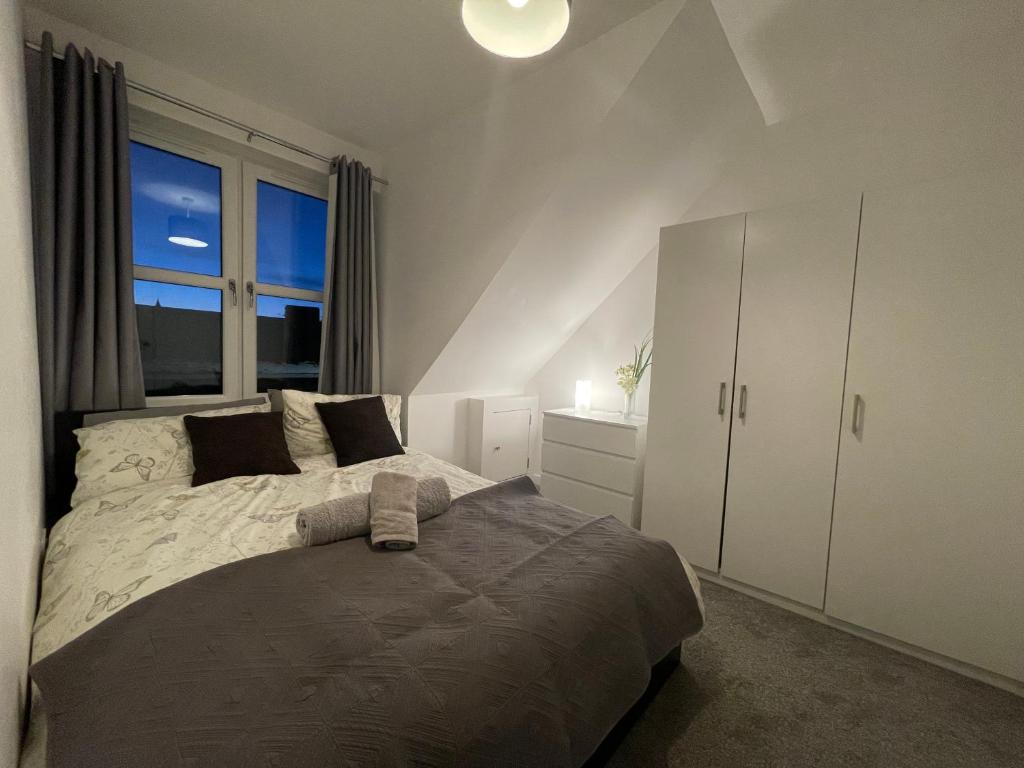 Un dormitorio con una cama grande y una ventana en Carvetii - Edward House D - 2 Dbl bed 2nd floor flat, en Dunfermline