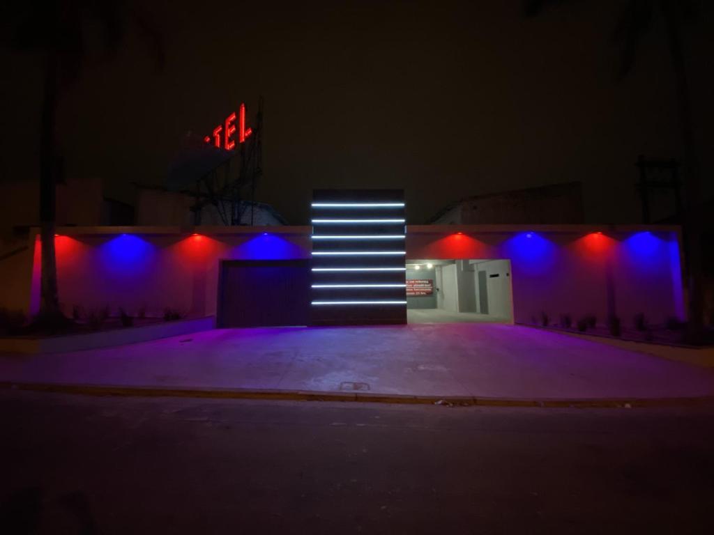 a building with purple and blue lights in the dark at Light Motel in Guarulhos