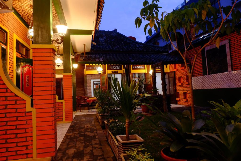 ジョグジャカルタにあるカムポエン ジャワ ホテルの植物と灯りの中庭のある家