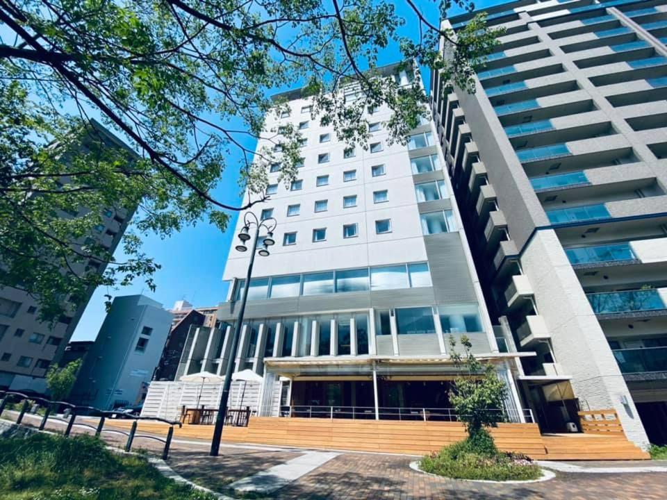 a large white building in front of a building at Hotel Flex in Hiroshima