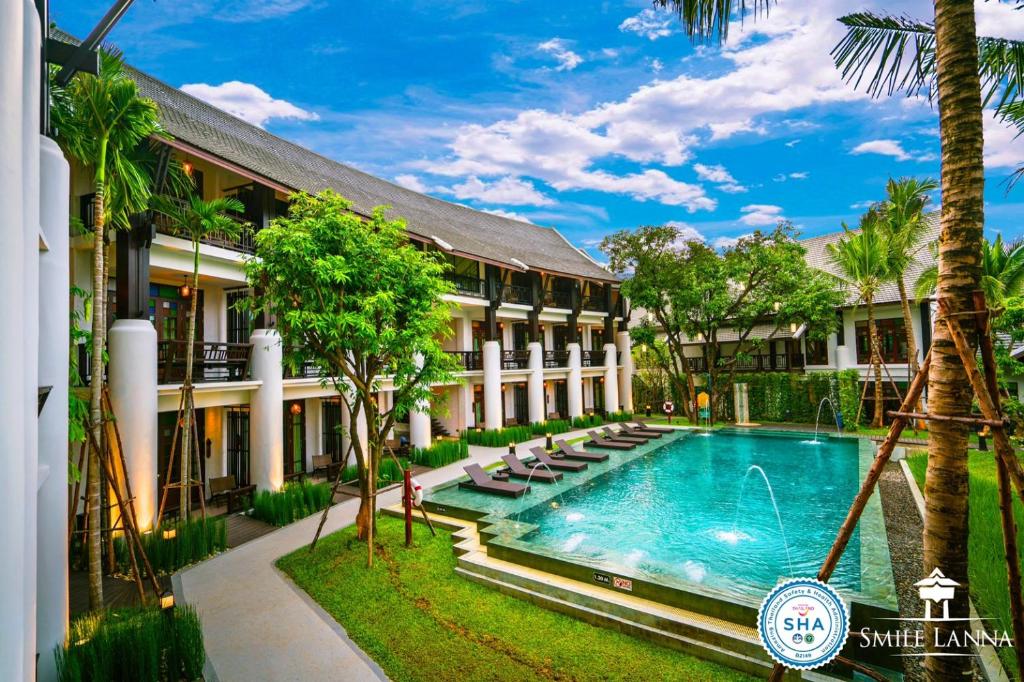 um hotel com piscina em frente a um edifício em Smile Lanna Hotel em Chiang Mai
